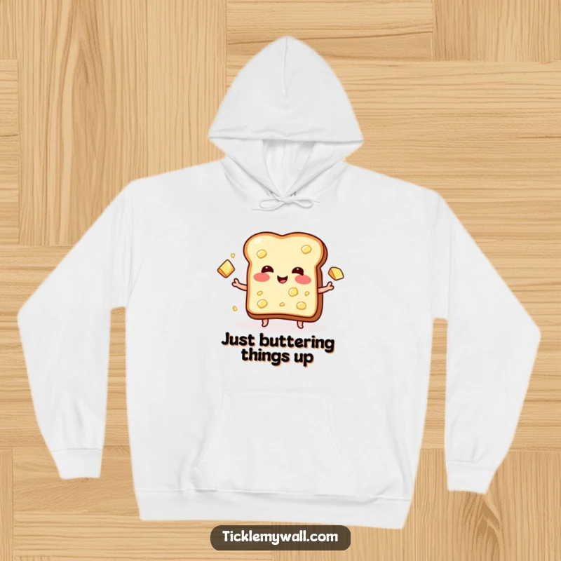 Funny hoodie with a blushing piece of toast joyfully juggling butter pats, exuding warmth and a playful breakfast theme.