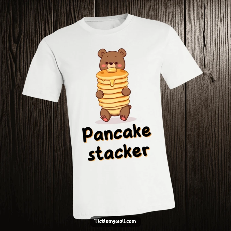 Funny t-shirt showing a clumsy bear struggling to balance a wobbly stack of three pancakes. Perfect for breakfast lovers and clumsy folks.